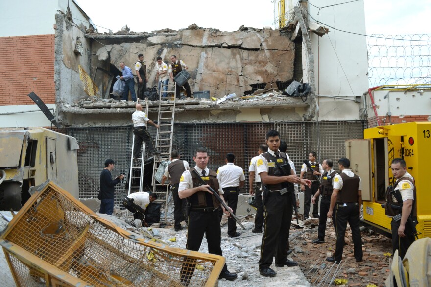 Guards and police inspect a vault that the assailants blew up early Monday morning in Ciudad del Este, Paraguay.