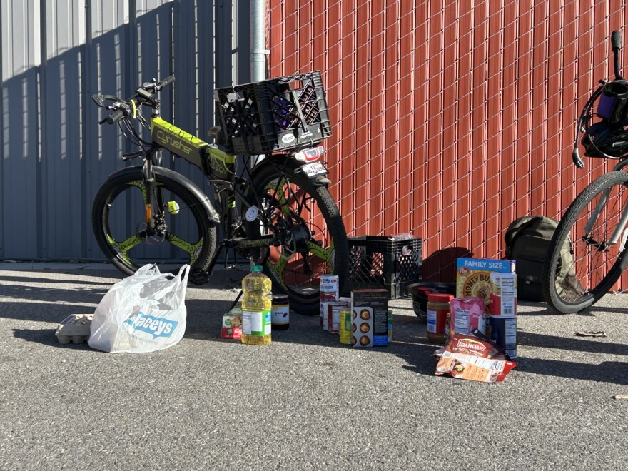 A variety of food sits in front of a bike