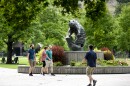 People walk in front of a grizzly bear statue on the University of Montana Campus, July 7, 2021.