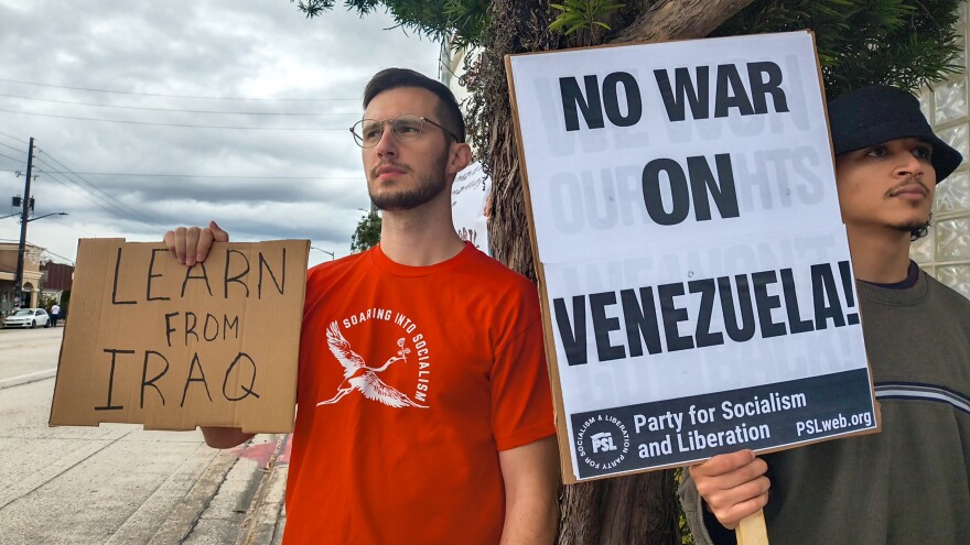 Matthew Houff (left) carries a sign that reads “Learn from Iraq” at Saturday’s protest. “(Interventionist) wars are meant to secure interests abroad, all the while ignoring the right to self-determination of the nation itself,” he said.