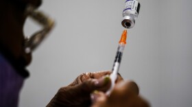 A syringe is prepared with the Pfizer COVID-19 vaccine at a vaccination clinic in Chester, Pa., on Dec. 15, 2021. Pfizer says tweaking its COVID-19 vaccine to better target the omicron variant is safe and boosts protection.