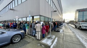 a line of people stand outside