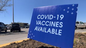 A sign advertises vaccine availability outside a grocery store in Hays.