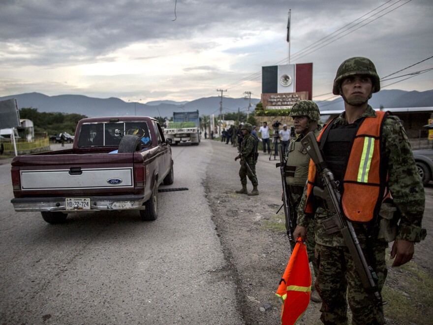 Groups of rural and community police arrive in the city of Iguala on Tuesday to help in the search for 43 students who disappeared after a confrontation with local police on Sept. 26.