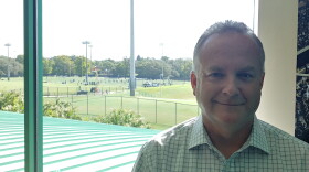 New USF Vice President of Athletics Michael Kelly stands in his office on the Tampa campus Tuesday while the football team practices outside.
