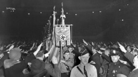 FILE - The crowd responds with a Hitler salute as uniformed members of a German-American Bund color guard march at a gathering in New York's Madison Square Garden, Feb. 20, 1939. (AP Photo/File)