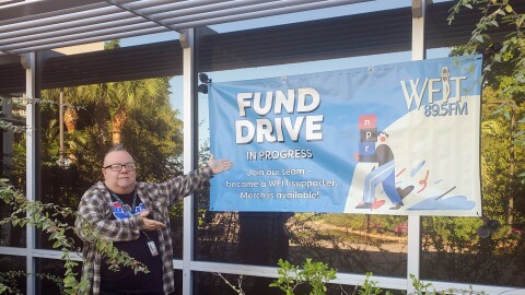 Steve Keller showing off the WFIT "Fund Drive in Progress" banner outside of WFIT studios