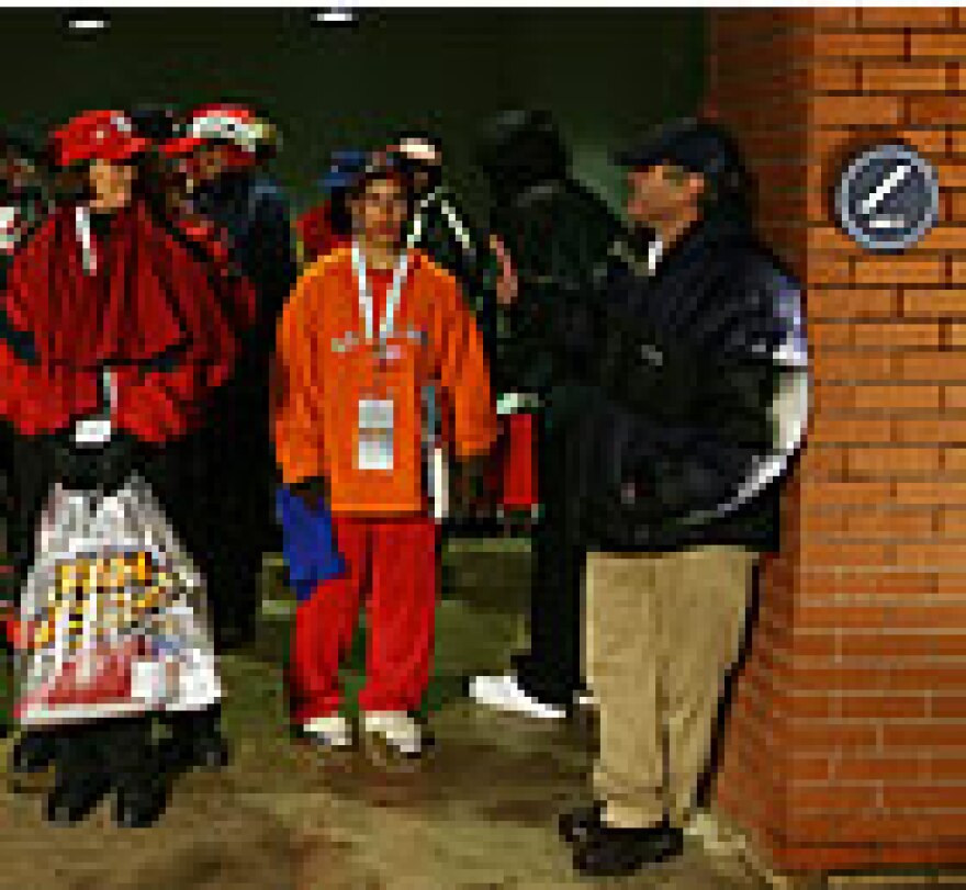 Fans find shelter in a stairwell as a steady rain falls at Busch Stadium eventually forcing the cancellation of Wednesday's game. (UPI Photo/Bill Greenblatt)
