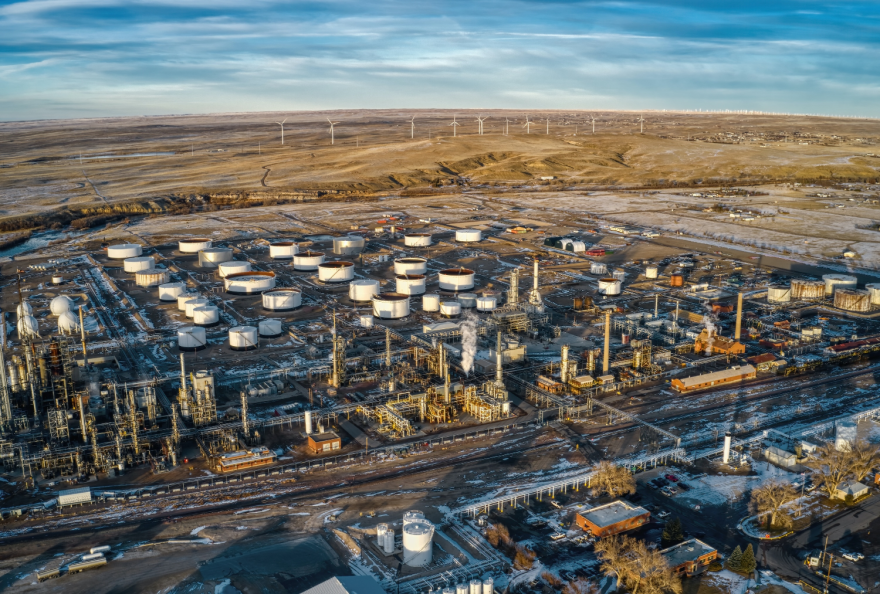 Aerial view of a sprawling oil refinery in a rural area.