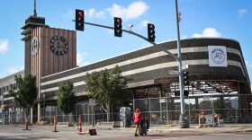 A woman pushes a a cart across the street at the intersection of Main Street and Westport Road near the remodeling of the former Katz Drug Co. building.