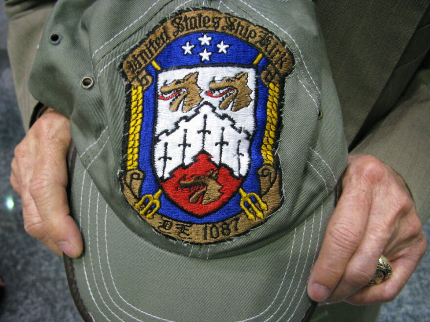 Pierre Le shows off the patch that a crew member of the USS Kirk gave him 35 years ago. He has kept it ever since.