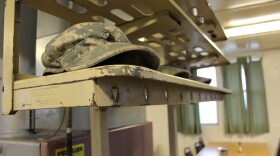 Soldiers place their hats on rack just inside the mess hall doors before eating breakfast in the controlled monitoring area at JBLM.