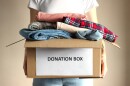 person holds a box with clothing donations