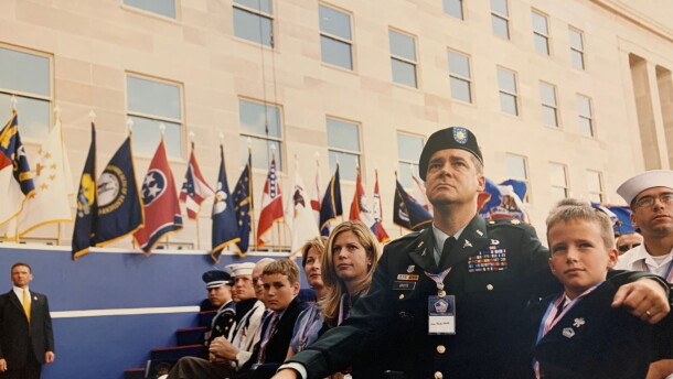 A group of military members and their families are sitting while attending a ceremony.
