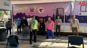 Staff at CrescentCare clinic in New Orleans pose outside the mobile unit they've established to test for COVID-19.  