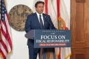 Gov. Ron DeSantis, shown releasing his proposed budget, wants a state “DOGE” to look for waste in government.