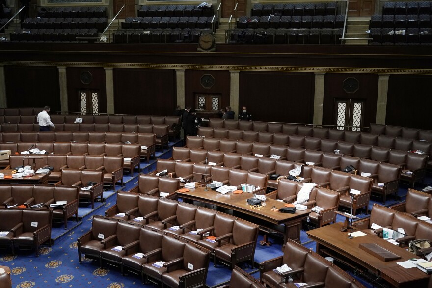 Papers and masks remain behind after House members left the floor of the House chamber as protesters tried to break into it at the U.S. Capitol on Wednesday.