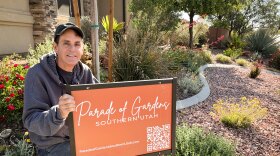 St. George resident Trase Taggart crouches in the desert garden outside his home, April 17, 2026. The area inside the concrete curbing used to be irrigated grass. Converting his HOA’s lawns to water-efficient landscaping saved the neighborhood water and money.