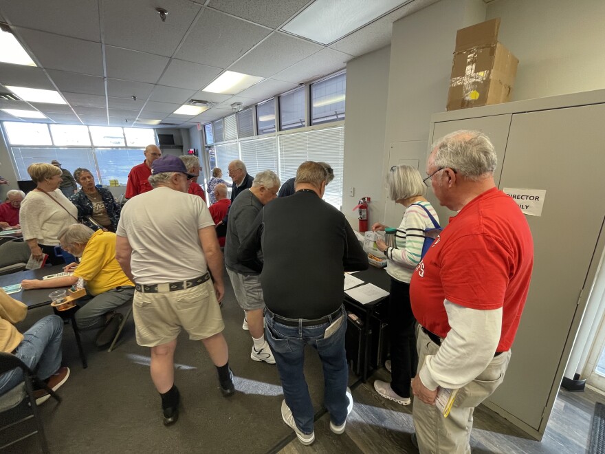 Bridge players check their scores at the conclusion of the busy Friday afternoon session.