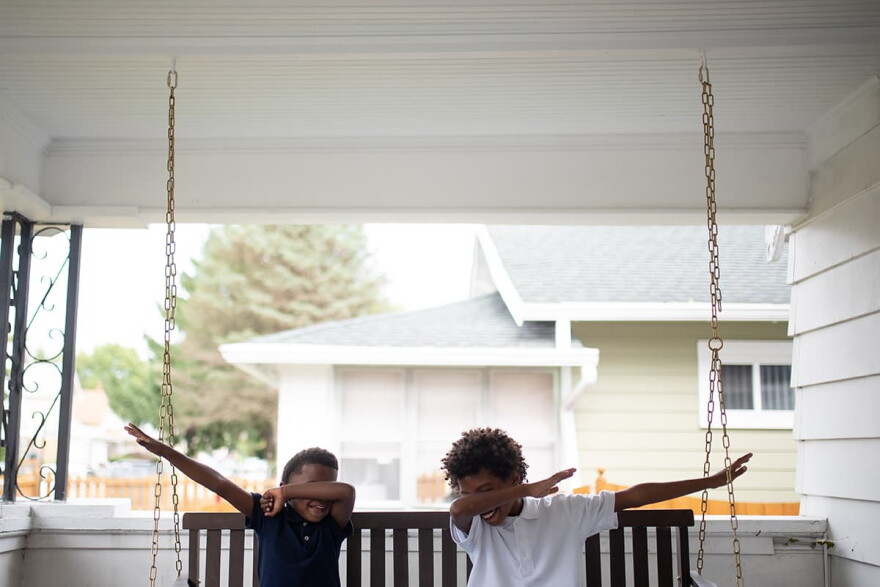 Ocean, 6, and Josh, 8, dab on the front porch adjacent to The Biker Boyz & Girlz Shop in Indianapolis. (Lucas Carter for Here & Now)