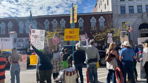 Protesters hold signs and chant along Main St. in Concord at a No Kings rally in opposition to the Trump administration on Oct. 18, 2025.