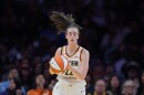 Indiana Fever guard Caitlin Clark (22) dribbles during the first half of a WNBA basketball game against the Los Angeles Sparks Wednesday, May 13, 2026, in Los Angeles. She has brown hair in a ponytail with a thin white headband. She's wearing a Fever uniform; it is white with yellow and blue stripes at the neck. 
