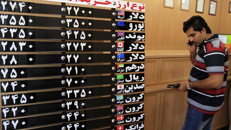 An Iranian man checks the rates of foreign currencies at a currency exchange bureau in central Tehran on Sept. 29. The Iranian currency lost nearly one-third of its value in a day over the weekend.