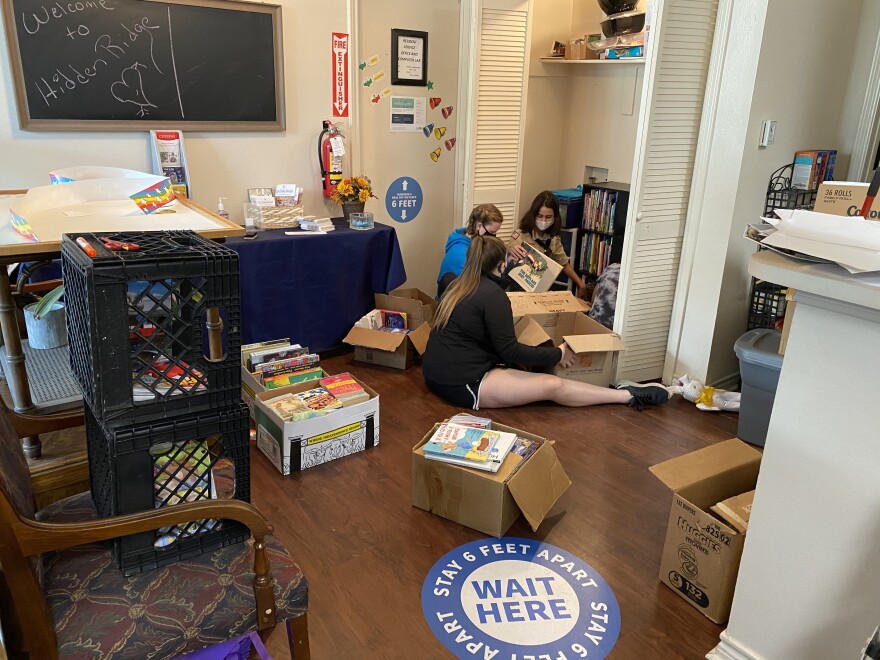 Madison Knefley and other scouts from Troop 890 sort through boxes filled with books in the community room at a Lake Highlands public housing complex as part of her eagle project. She also put together craft packets for kids, like homemade bracelets and bookmarks, and made "reading cushions" by repurposing grocery bags and memory foam. 