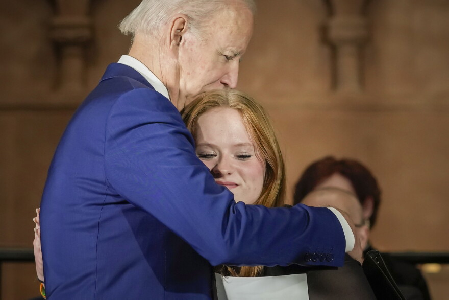 President Joe Biden hugs Sandy Hook survivor Jackie Hegarty, who introduced him, during an event in Washington, Wednesday, Dec. 7, 2022, with survivors and families impacted by gun violence for the 10th Annual National Vigil for All Victims of Gun Violence.
