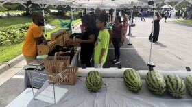 Thelonious Cook chats with customers at his produce stand outside E. Palmer Supermarket during the Mid-Atlantic Black Farmers Market in Berkley. The market runs on the first and third Saturday of each month through November.