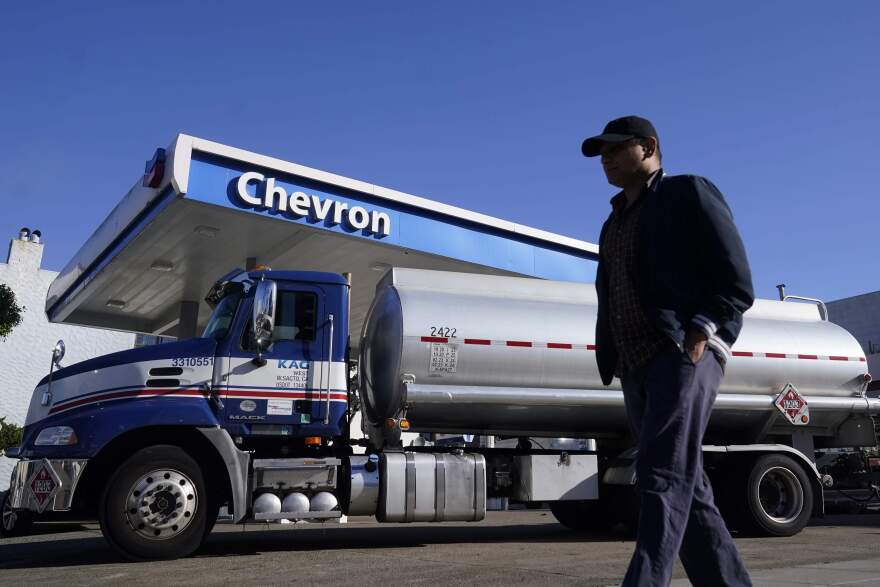 A pedestrian walks past a tanker at a Chevron gas station. (Jeff Chiu/AP)