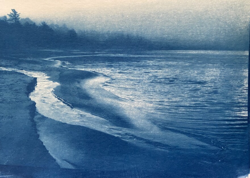 A photo of waves rolling towards the shore with a deep blue tint. 