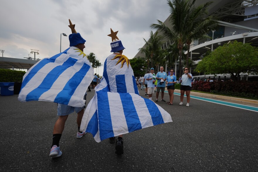 Uruguay fans wrapped in national flags arrive at the stadium prior to the World Cup Group H soccer match between Saudi Arabia and Uruguay in Miami Gardens, Fla., Monday, June 15, 2026.