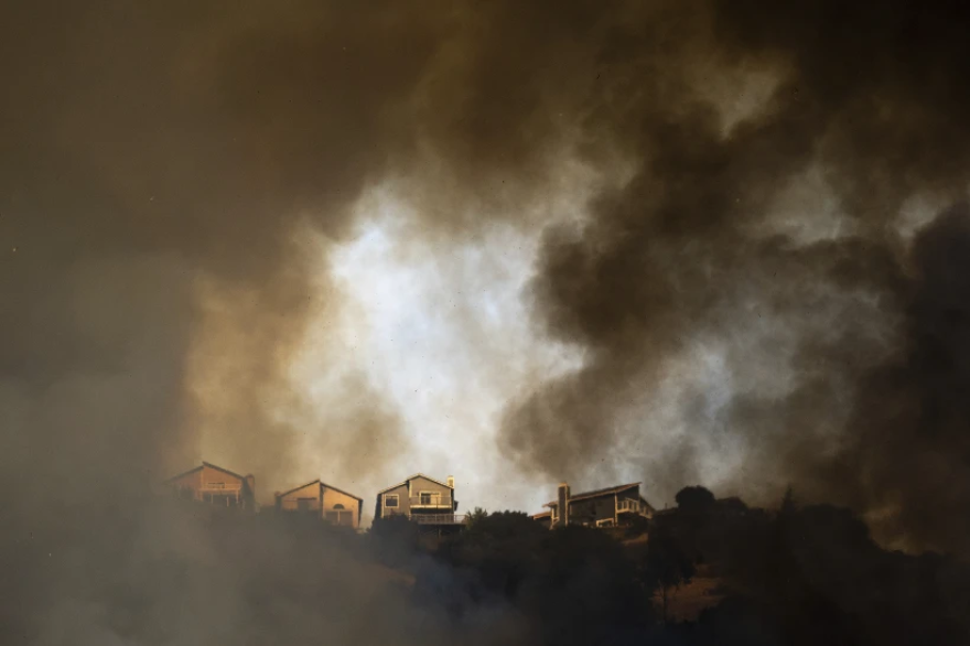 Smoke rises above during a grass fire in Oakland, Calif. on Friday, Oct.18, 2024.