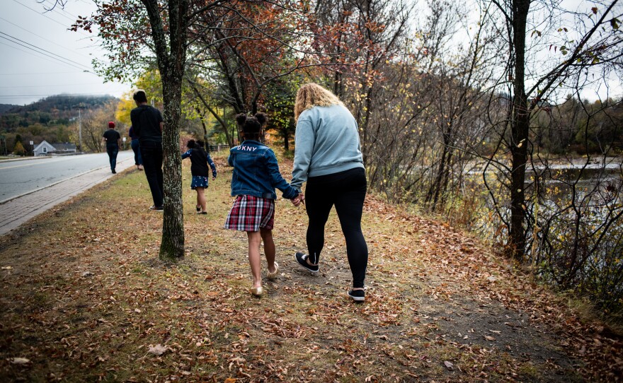 Vanessa Shefer (right) walks with her family along the Passumpsic River in St. Johnsbury, Vt.