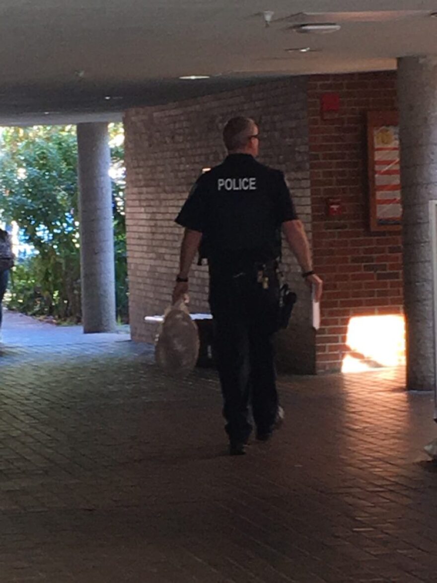 A police officer carries a noose in Weimer Hall today. (Lena Schwallenberg/WUFT News)