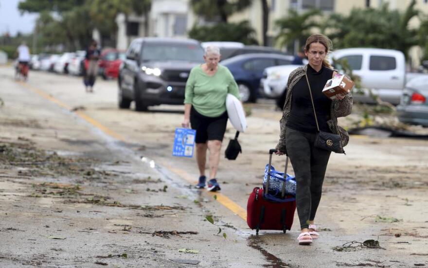 King Point residents leave with their belongings after an apparent overnight tornado spawned from Hurricane Ian at Kings Point 55+ community in Delray Beach, Fla., on Wednesday, Sept. 28, 2022.