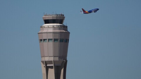 A plane takes off near the air traffic control tower at Harry Reid International Airport, Tuesday, Oct. 7, 2025, in Las Vegas.