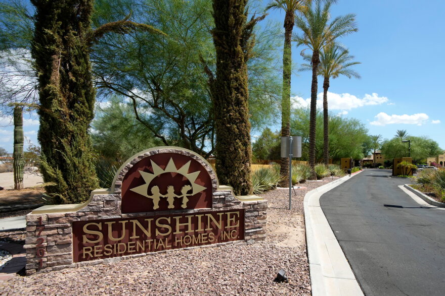 Brick sign that's yellow and red reads Sunshine Residential Homes, Inc. in driveway