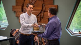 Chief of the Peoria Tribe of Indians of Oklahoma, Craig Harper, shakes hands with Chief of the Modoc Nation, Robert Burkybile, as a 100-year-old basket is returned to the Modoc Nation.