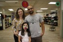 Jenna Carroll, Chuda Mishra and their daughter, Sofia, stand inside the Keene International Market.