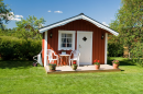 a small red house with red trim and a tiny front porch.