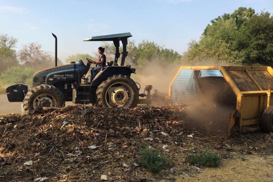 Former Director Nidhi Solanki of Project Compost uses a tractor and compost turner to turn food waste into compost.