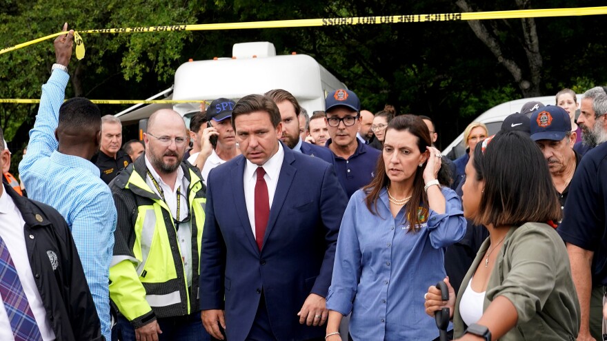 Florida Gov. Ron DeSantis, center left, and Lt. Gov. Jeanette Nunez, center right, arrive for a news conference near the scene where a wing of a 12-story beachfront condo building collapsed, Thursday, June 24, 2021, in the Surfside area of Miami