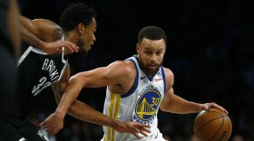 Golden State Warriors guard Stephen Curry (30) drives past Brooklyn Nets center Nic Claxton (33) during the first half of an NBA basketball game Monday, Feb. 5, 2024, in New York. (AP Photo/John Munson)