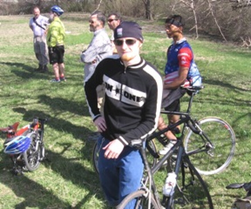Bicyclists gather to watch ground breaking for new bridge path.