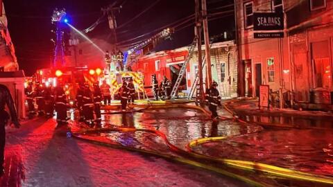 Firefighters battle a three-alarm fire on Custom House Wharf in Portland on Friday, Dec. 26, 2025.