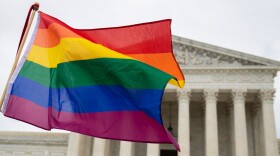 FILE - Supporters of the LGBT wave their flag in front of the U.S. Supreme Cour, Oct. 8, 2019, in Washington.