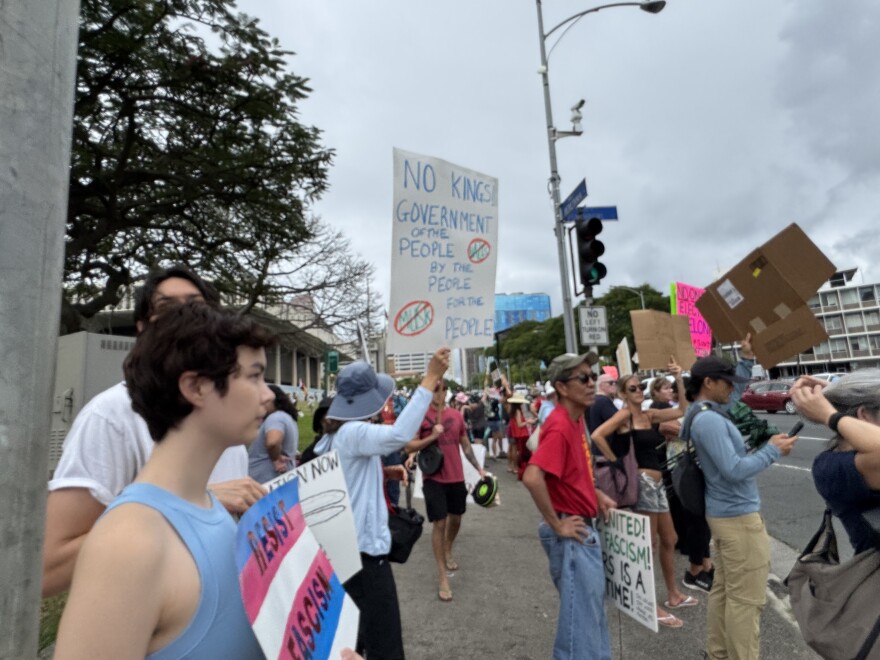 Demonstrators and posters during a rally to protest President Trump’s politics on Presidents Day, Monday, Feb. 17, 2025, at the Hawaiʻi State Capitol in Honolulu.