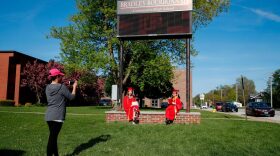 Students Maria Sosa (C) and Paulyn Bernadit (R) pose for a picture outside Bradley-Bourbonnais Community High School after picking up their diplomas during a graduation ceremony in Bradley, Illinois.